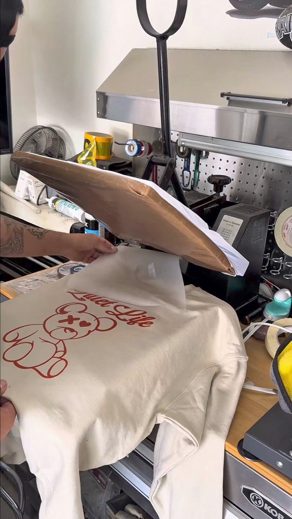 Customer peeling a DTF transfer after heat pressing a garment