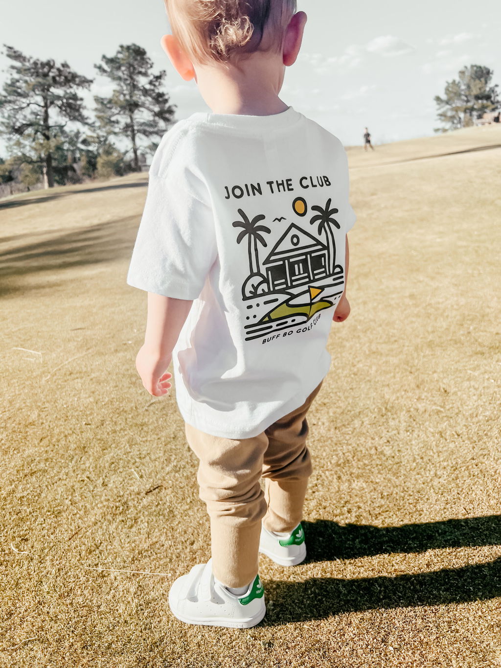 Child wearing a white shirt with crisp black line art and small lettering