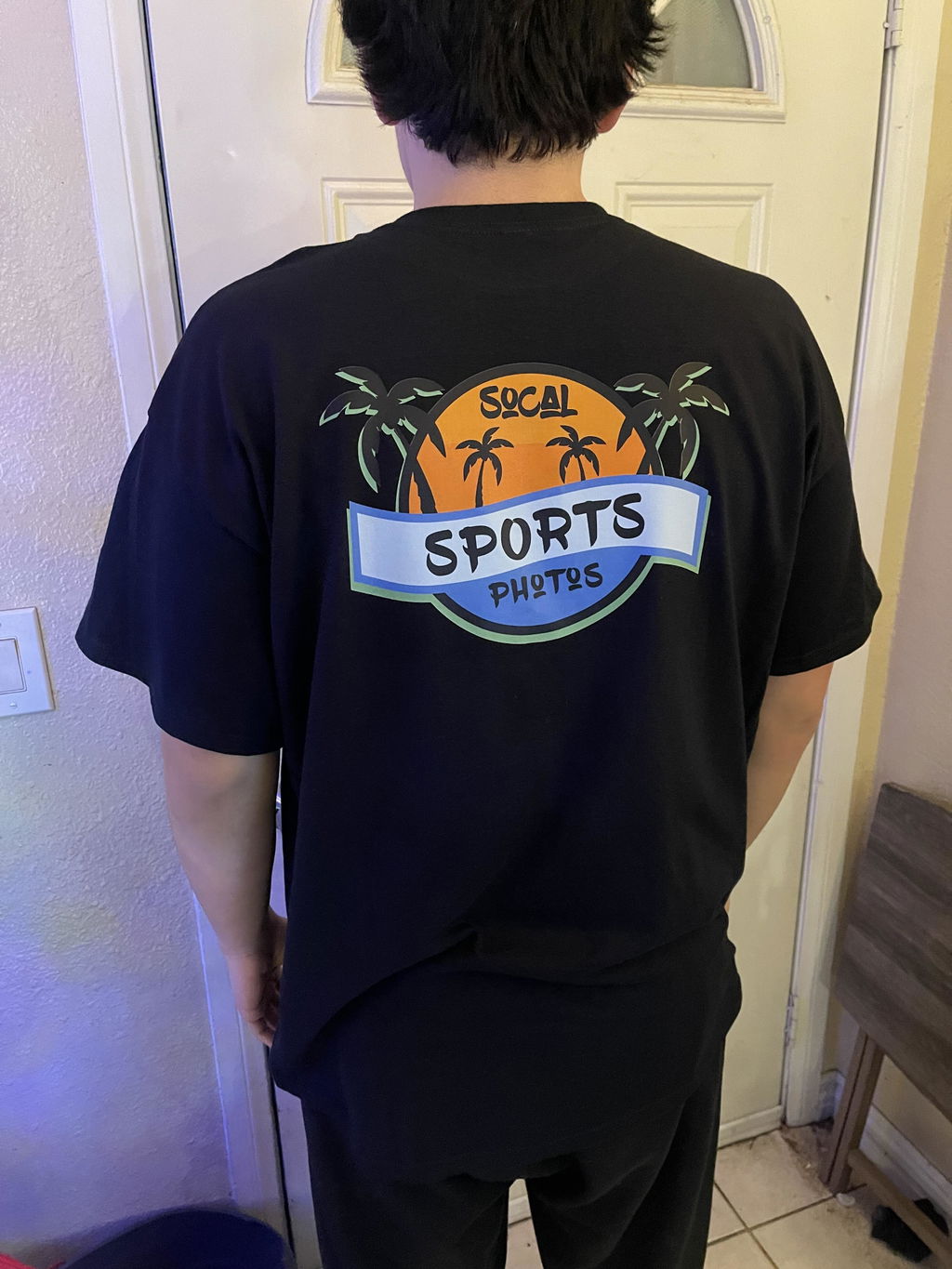 Customer wearing a black shirt with a colorful back print