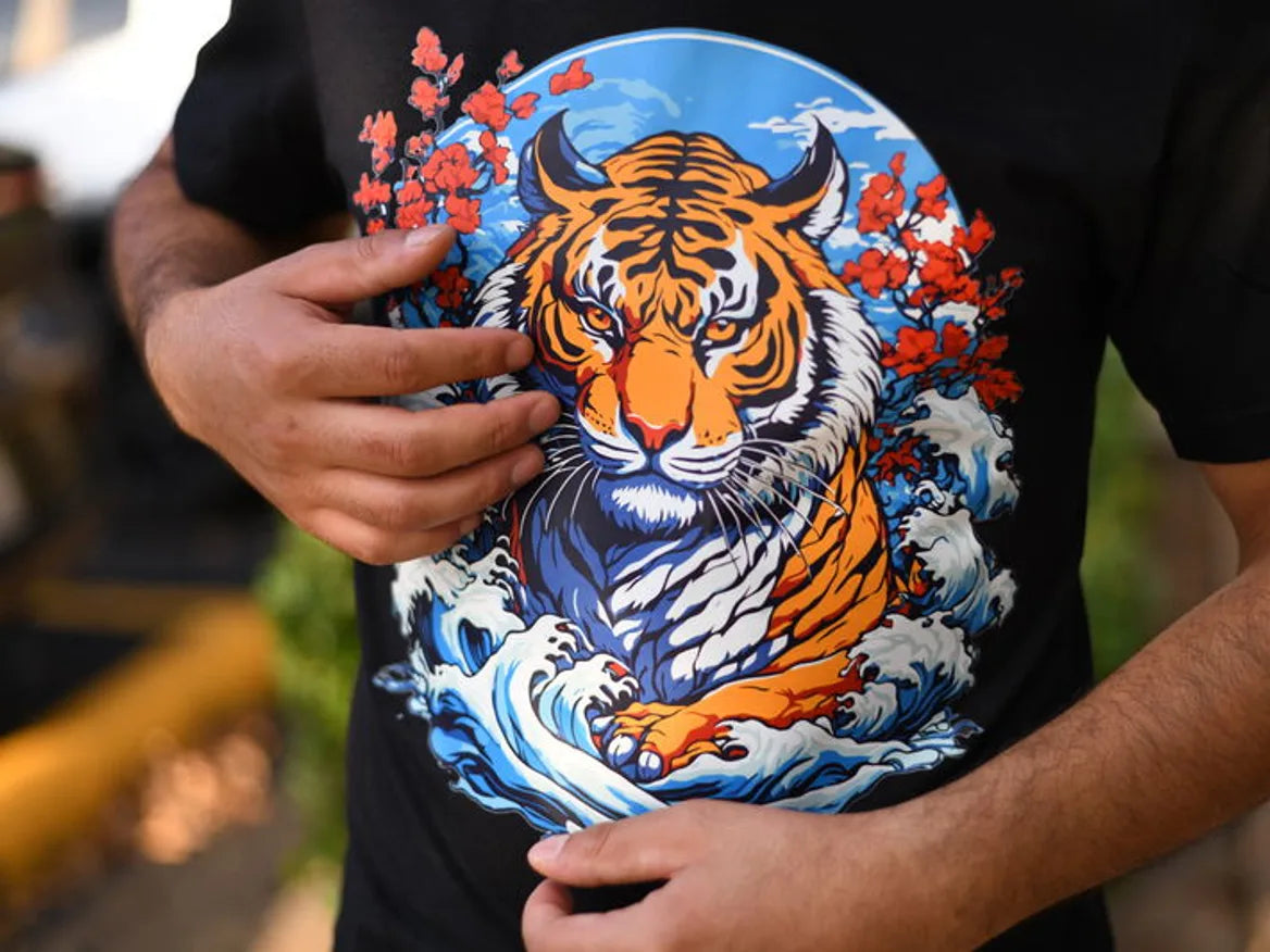 A finished tiger print being held against the shirt fabric